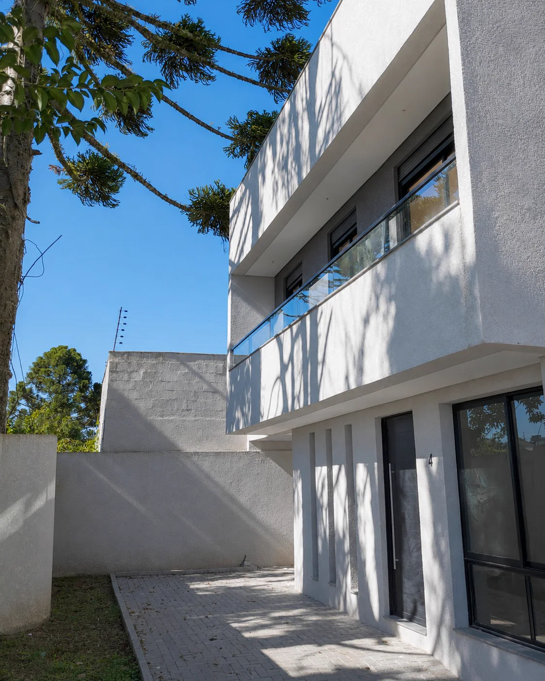 Fachada do Villa Rica em tons claros, com esquadrias escuras e guarda-corpo de vidro.